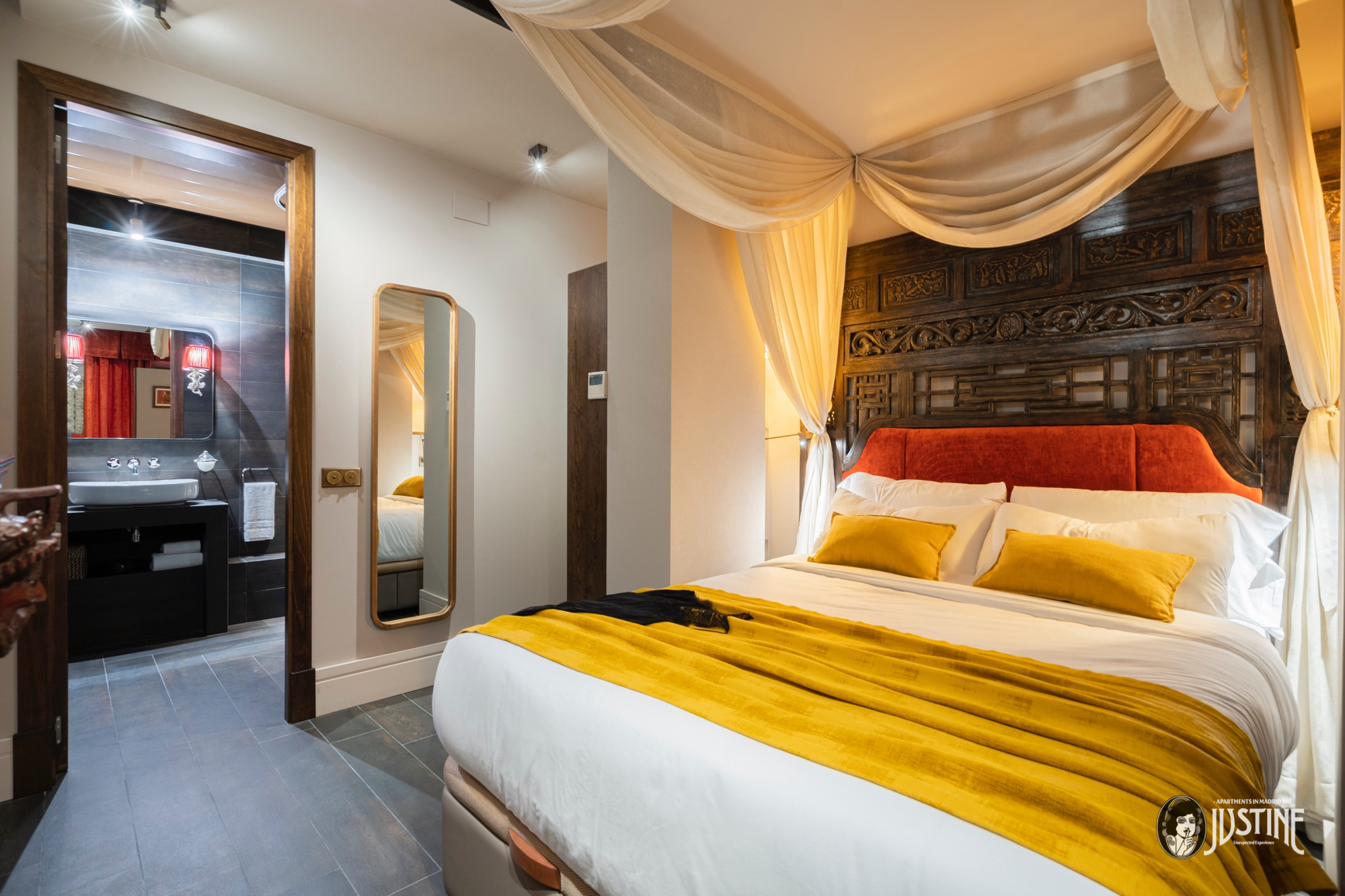Apartamento Opium Den en Madrid Río con cama de inspiración china, dosel dorado y mobiliario oriental decadente.