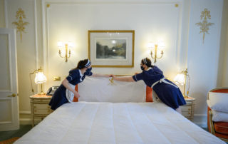 LONDON, ENGLAND – MAY 13: Housekeeping staff Natalia Blazeckova (L) and Agata Kucz (R) make up a bed in one of the classic suites at The Ritz London on...